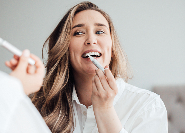 Swiss Clinic Teeth Whitening Pen används av en kvinna